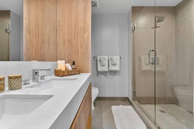 a bathroom with two sinks and a glass shower at The Crosby Miami Worldcenter Downtown Miami in Miami