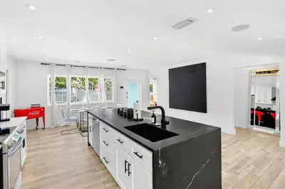 a kitchen with a sink and a black counter top at Spacious Miami 4BR Retreat with Pool & BBQ in Miami