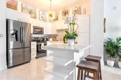 a kitchen with a stainless steel refrigerator and white cabinets at Downtown Apartment with free parking near Brickell in Miami