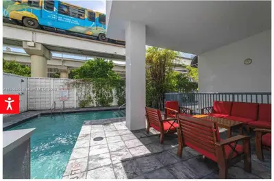 a pool with a table and chairs and a bus on a building at Downtown Apartment with free parking near Brickell in Miami