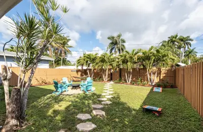 a yard with two blue chairs and a hammock at Tropical Retreat with Private Yard, Fire Pit, Hammock in Hollywood