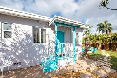 a white house with a blue door at Tropical Retreat with Private Yard, Fire Pit, Hammock in Hollywood