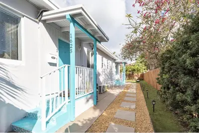 a house with a blue door and a porch at Tropical Retreat with Private Yard, Fire Pit, Hammock in Hollywood