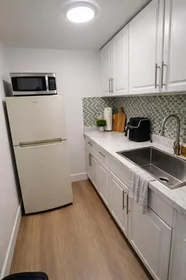 a kitchen with a white refrigerator and a sink at Fort Lauderdale Airport Pacifica Lake Bleu in Dania Beach