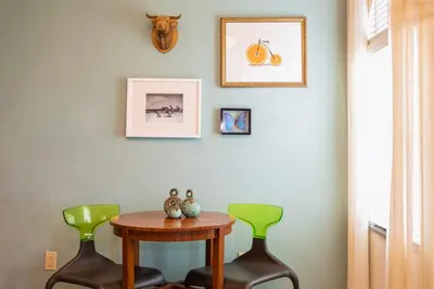 a table and two green chairs in a room at Kasa El Paseo Miami Beach in Miami Beach