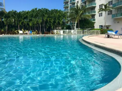 a large swimming pool with blue water in a resort at Ocean Reserve Miami Luxury Rentals in Sunny Isles Beach