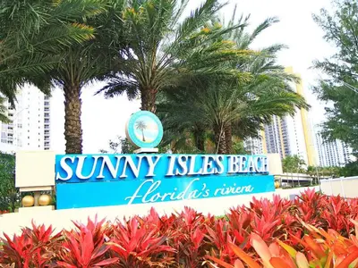a sign for sunny isles beach with palm trees at Penthouse Ocean Reserve in Miami Beach