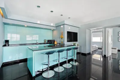 a blue kitchen with a bar with stools at Casa Grande Suites on Ocean Drive in Miami Beach