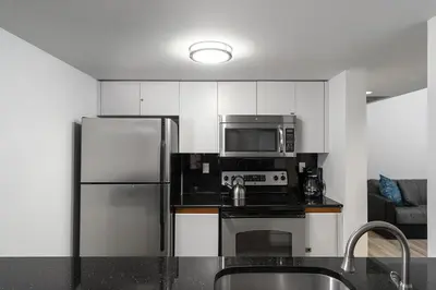 a kitchen with a stainless steel refrigerator and microwave at Casa Grande Suites on Ocean Drive in Miami Beach