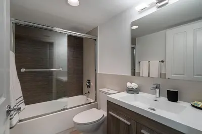 a bathroom with a toilet and a sink and a mirror at Casa Grande Suites on Ocean Drive in Miami Beach