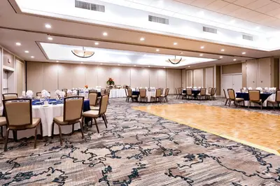 a banquet hall with tables and chairs and a large rug at Holiday Inn Miami West - Airport Area by IHG in Hialeah Gardens