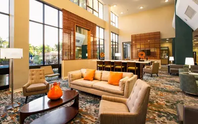 a living room with a couch and chairs and a table at Holiday Inn Miami West - Airport Area by IHG in Hialeah Gardens