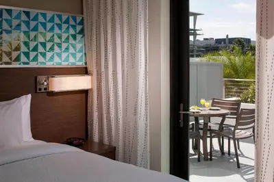 a bedroom with a bed and a balcony with a table at Residence Inn by Marriott Miami Beach South Beach in Miami Beach