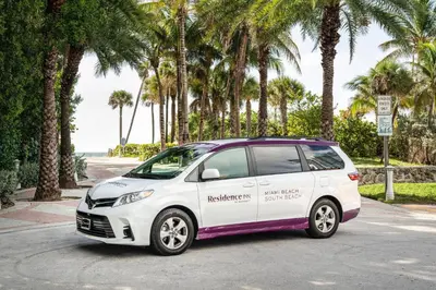 a white car parked in a parking lot with palm trees at Residence Inn by Marriott Miami Beach South Beach in Miami Beach