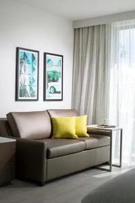 a living room with a brown couch with yellow pillows at Residence Inn by Marriott Miami Beach South Beach in Miami Beach