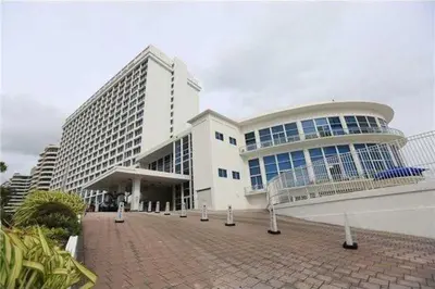 a large white building with a walkway in front of it at Castle Beach Club Apartments in Miami Beach