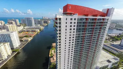 a tall white building with a red roof next to a river at Beachwalk Resort Residence in Hollywood