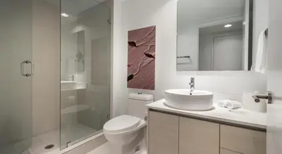 a bathroom with a toilet and a sink and a shower at Beachwalk Resort Residence in Hollywood