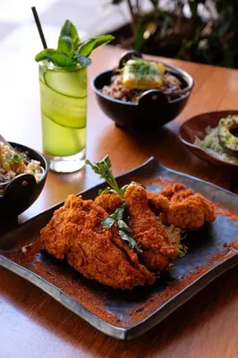 a plate of fried food on a table with bowls of food at The Plymouth South Beach in Miami Beach