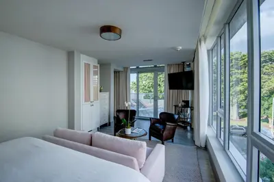 a bedroom with a couch and a living room with a view at The Plymouth South Beach in Miami Beach