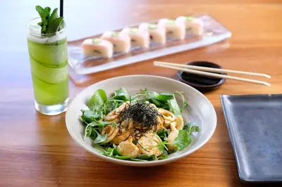 a bowl of salad and a drink on a table at The Plymouth South Beach in Miami Beach