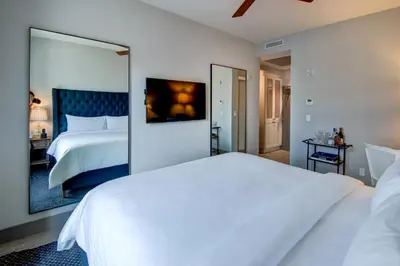 a bedroom with two beds and a large mirror at The Plymouth South Beach in Miami Beach