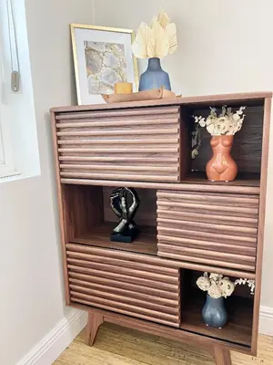 a wooden dresser with vases and flowers on it at Harmonious Suites in North Miami Beach