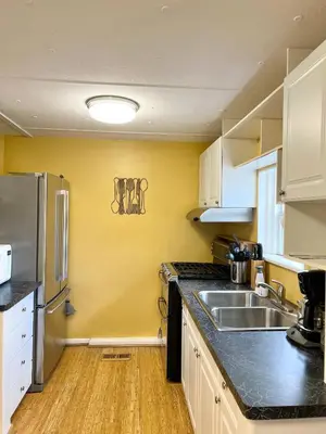 a kitchen with a sink and a refrigerator at Harmonious Suites in North Miami Beach