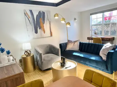 a living room with a blue couch and a chair at Harmonious Suites in North Miami Beach