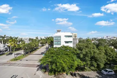 an empty street in front of a white building at The Meridian Hotel by At Mine Hospitality in Miami Beach