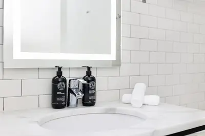 a bathroom sink with two bottles and a mirror at The Meridian Hotel by At Mine Hospitality in Miami Beach