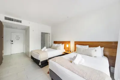 a hotel room with two beds and a hallway at The Meridian Hotel by At Mine Hospitality in Miami Beach