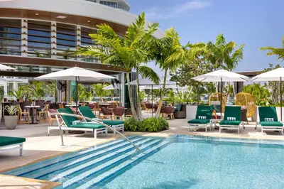 a pool with chairs and umbrellas next to a hotel at Pier Sixty-Six in Fort Lauderdale