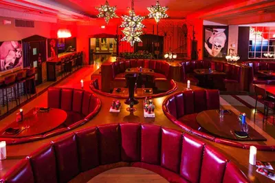 a restaurant with red chairs and tables in a room at Dream South Beach, by Hyatt in Miami Beach