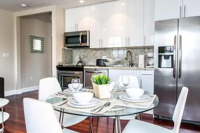 a kitchen with a glass table and white chairs at Hudson Apartments in Miami Beach