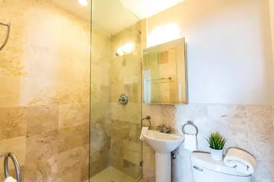 a bathroom with a shower and a toilet and a sink at Hudson Apartments in Miami Beach