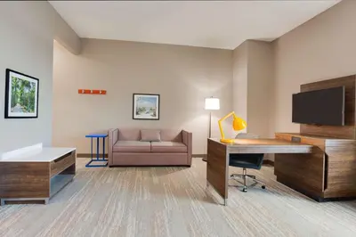 a hotel room with a couch and a desk and a television at Hampton Inn & Suites Fort Lauderdale - Miramar in Miramar