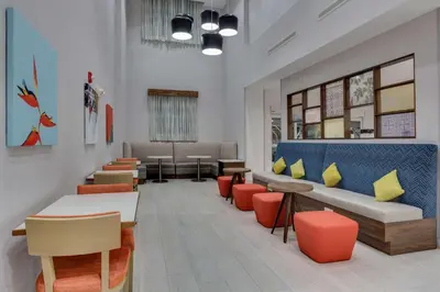 a waiting area with tables and chairs and a waiting room at Hampton Inn & Suites Fort Lauderdale - Miramar in Miramar