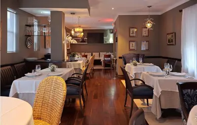 a dining room with tables and chairs with white tablecloths at Cadet Hotel in Miami Beach