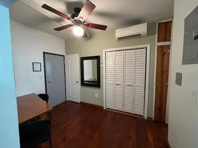 a living room with a ceiling fan and a table at Sherbrooke All Suites Hotel in Miami Beach
