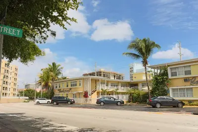 a street sign with cars parked in front of a building at Beach Place Hotel in Miami Beach