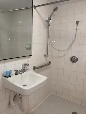 a white bathroom with a sink and a shower at Beach Place Hotel in Miami Beach