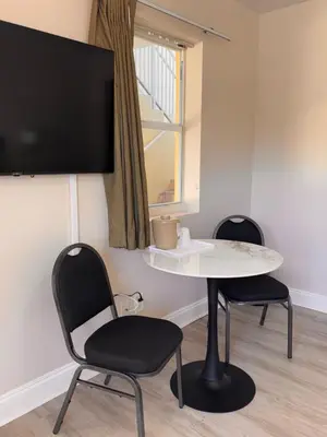 a room with a table and two chairs and a tv at Beach Place Hotel in Miami Beach