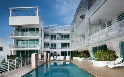 a building with a swimming pool in front of a building at SBV Luxury Ocean Hotel Suites in Miami Beach