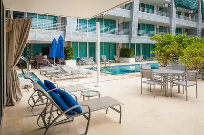 a hotel patio with tables and chairs and a pool at SBV Luxury Ocean Hotel Suites in Miami Beach