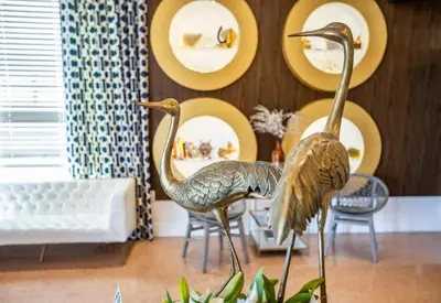 two statues of birds in a room with chairs at Oceanside Hotel and Suites in Miami Beach