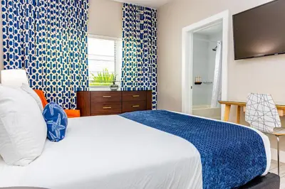 a bedroom with a large bed with blue and white patterns at Oceanside Hotel and Suites in Miami Beach