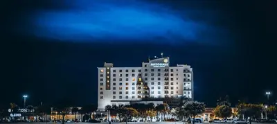 a large white building with a clock on top at night at Miccosukee Casino & Resort in Miami