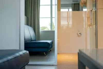 a living room with a blue chair and a window at Clevelander Hotel in Miami Beach