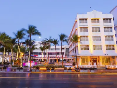 a building with palm trees in front of a street at Clevelander Hotel in Miami Beach